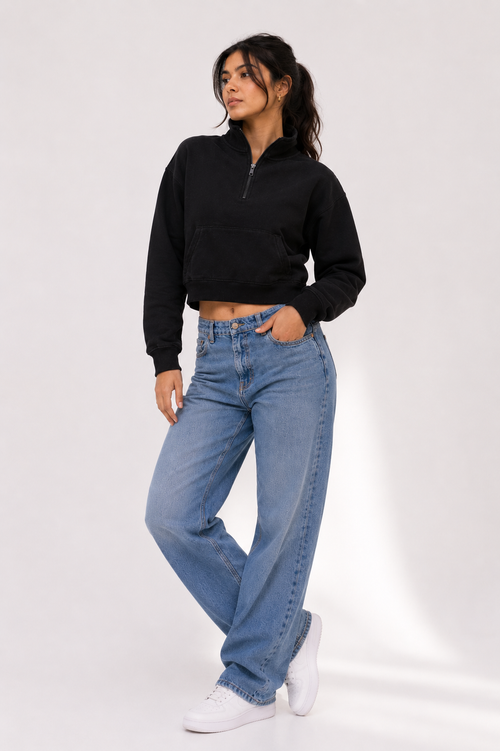 Female model wearing the Black Crop Zipper with light blue wide-leg denim, showcasing the relaxed cropped fit and minimalist design.
