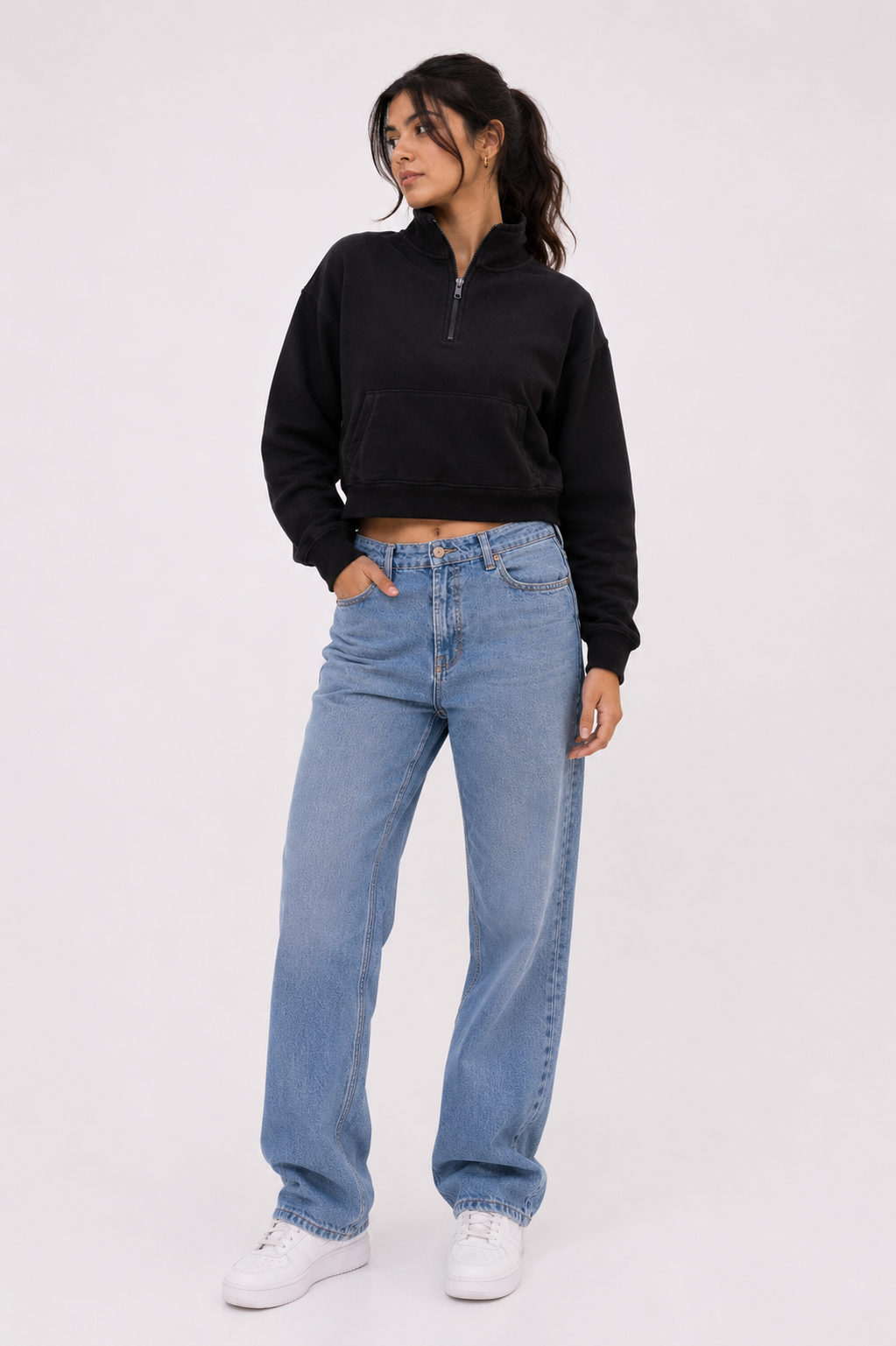 Female model wearing the Black Crop Zipper in a relaxed seated pose, emphasizing the cropped silhouette, premium fabric, and effortless everyday styling.