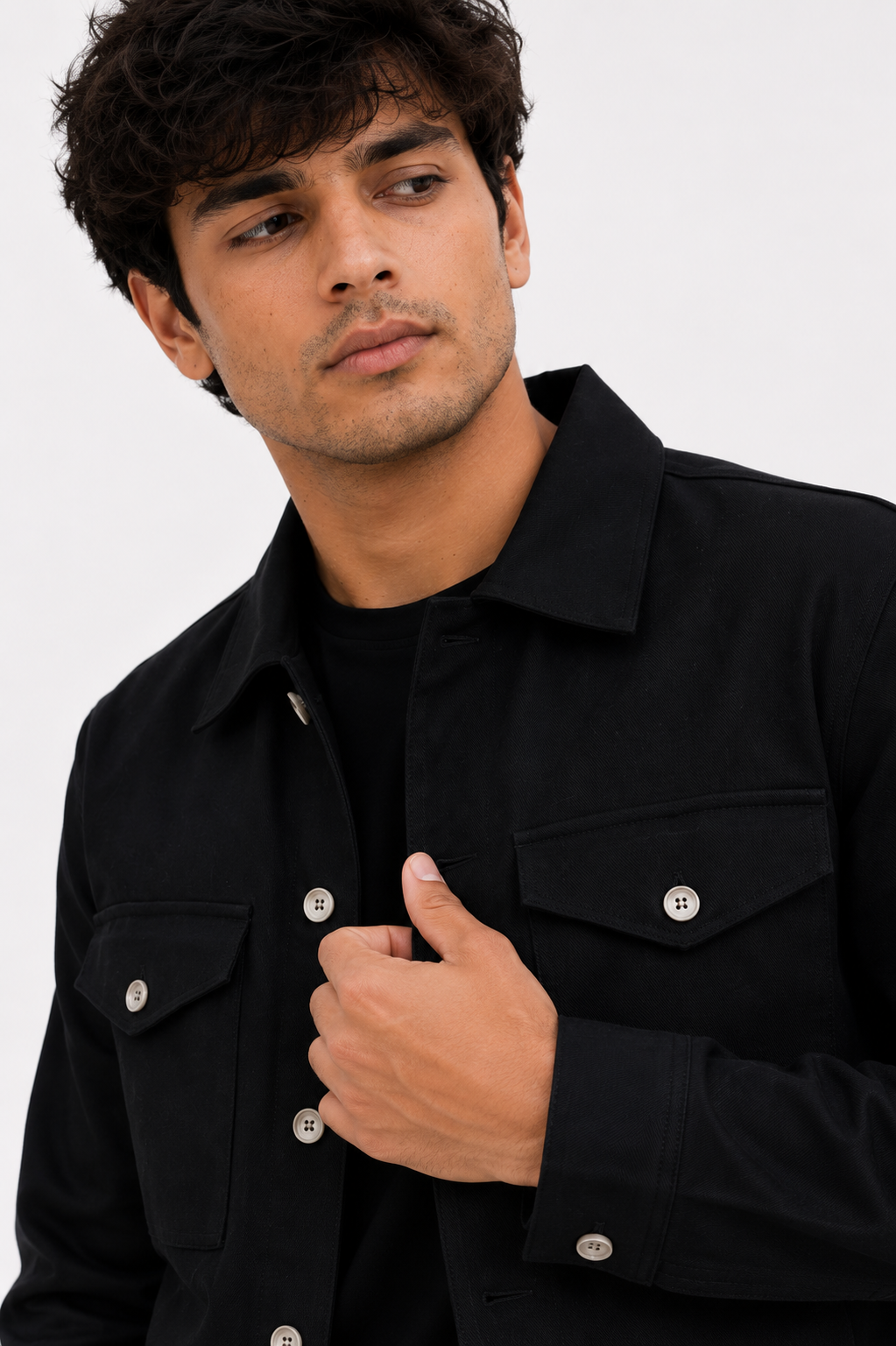 Close-up of the premium Black Denim Jacket featuring heavyweight black denim, clean tailoring, flap chest pockets, and metal button detailing.