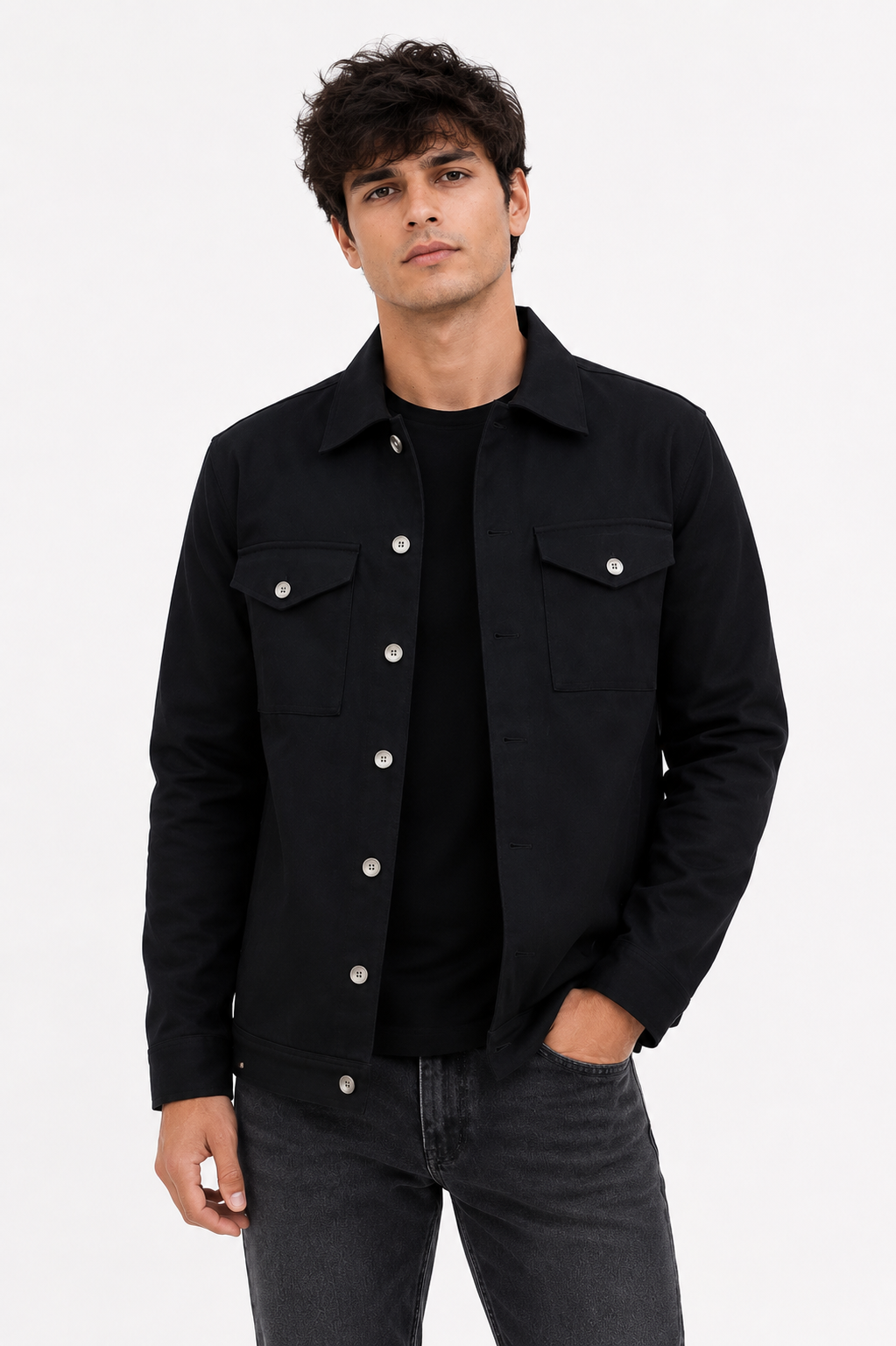 Male model seated wearing the Black Denim Jacket, showcasing its structured fit and timeless minimalist design.