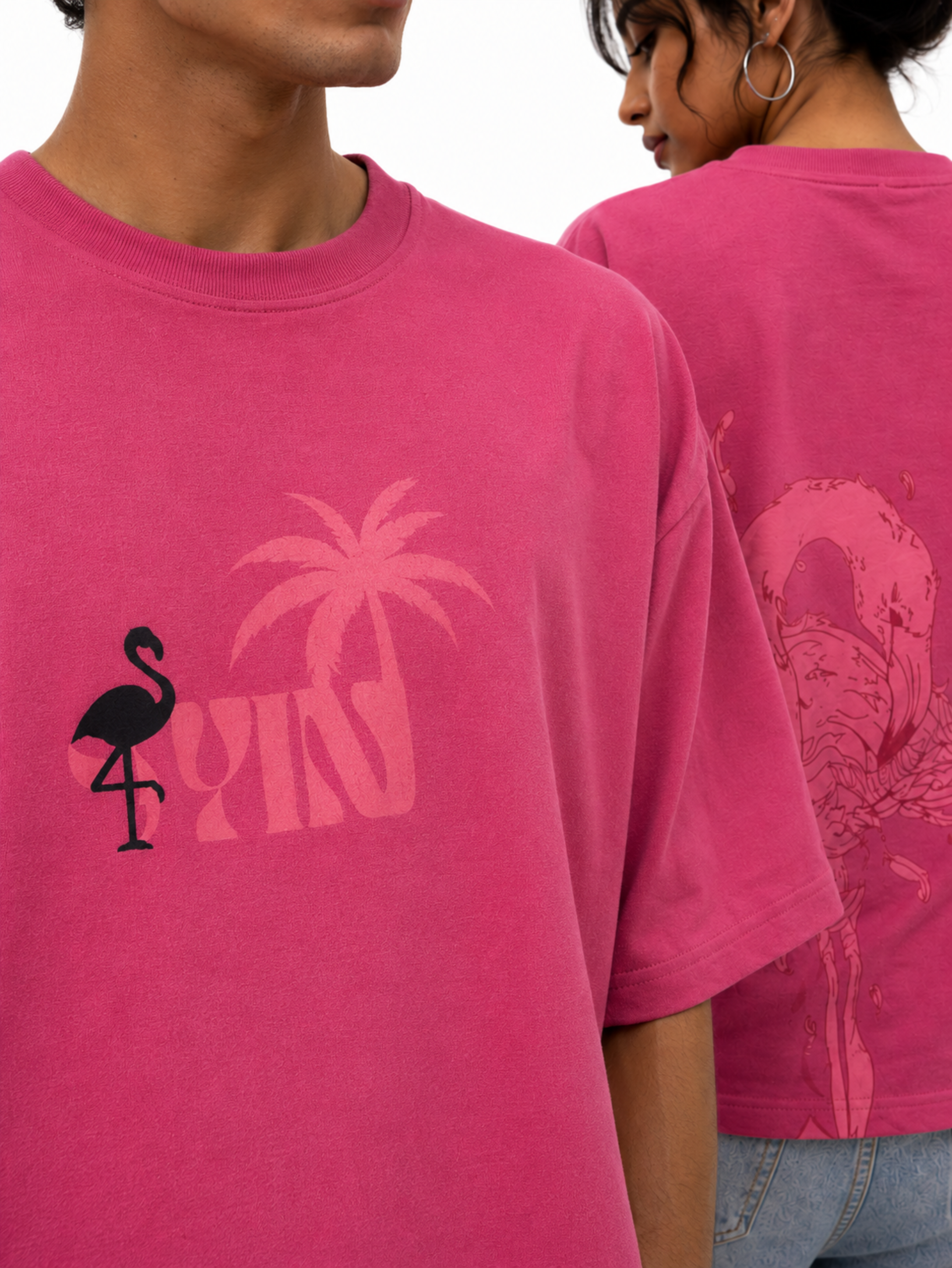 Close-up of Emerge in Pink oversized pink t-shirt highlighting SYIN tropical logo, flamingo artwork, and premium cotton fabric