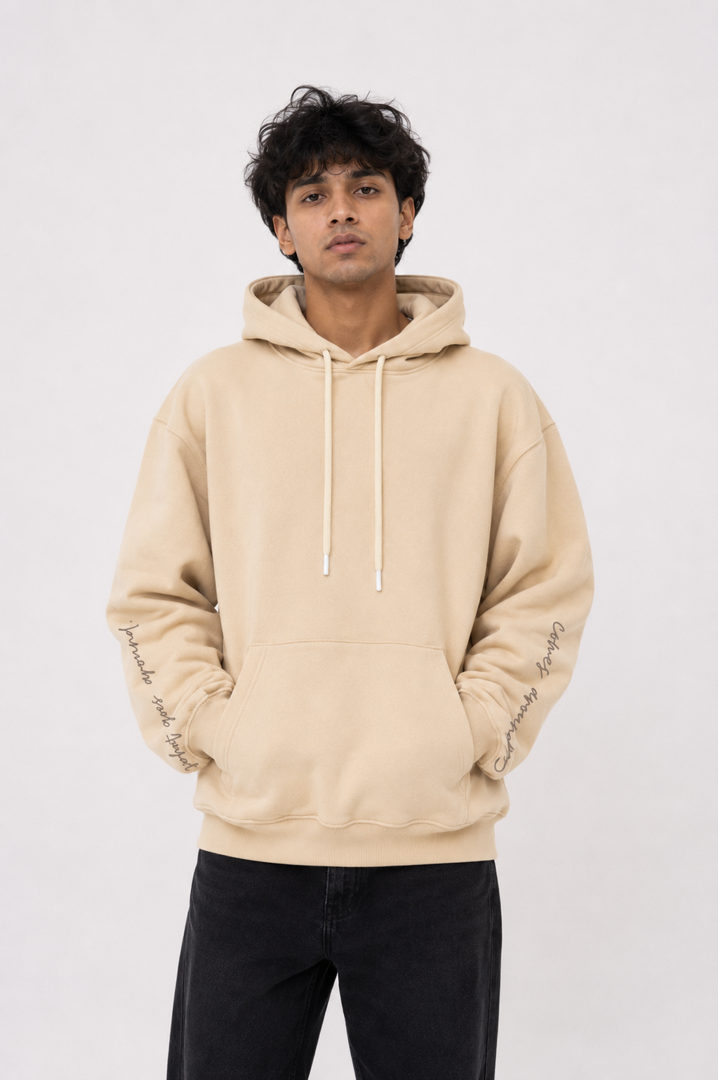 Male model wearing the Karmic Bloom oversized sand beige hoodie showcasing the clean minimalist front design and oversized silhouette.