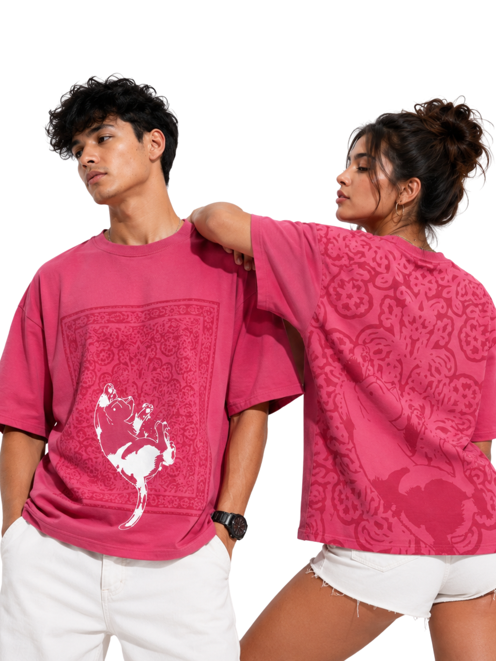 Male and female models wearing the Mid Air Myth oversized pink streetwear T-shirt by SYIN & SYRAH featuring a falling cat graphic on the front and matching Persian-inspired artwork on the back in a premium studio photoshoot.