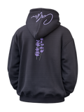 Back view of Midnight Lavender oversized black hoodie with lavender botanical print and signature hood artwork on a transparent background.