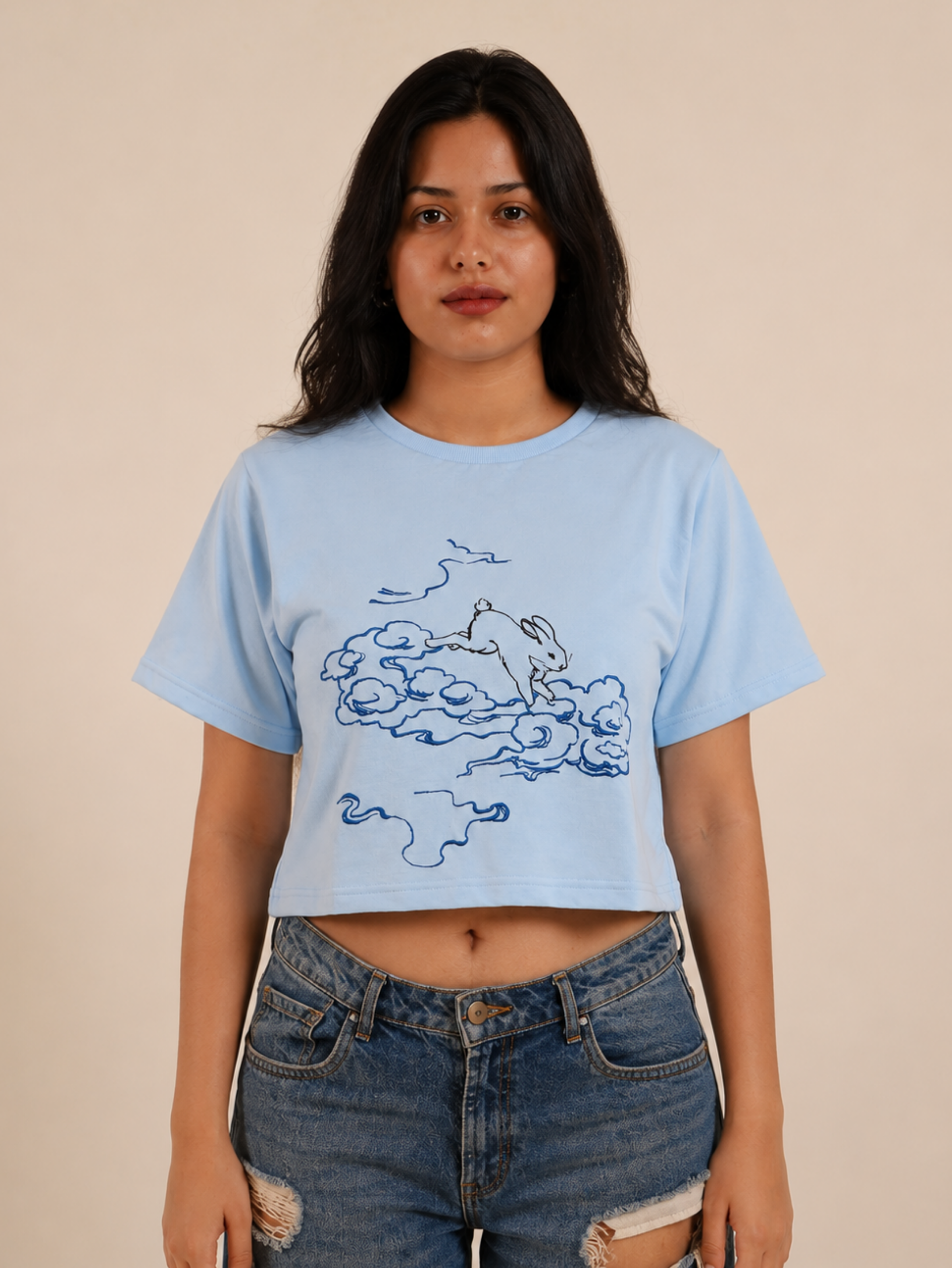 Female model wearing Puffy Dreams sky blue graphic crop top