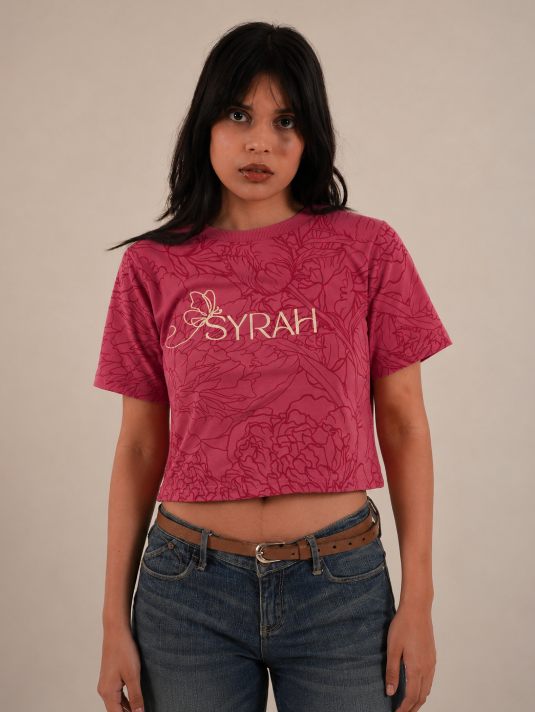 Female model wearing Rose Bloom pink floral crop top with denim jeans