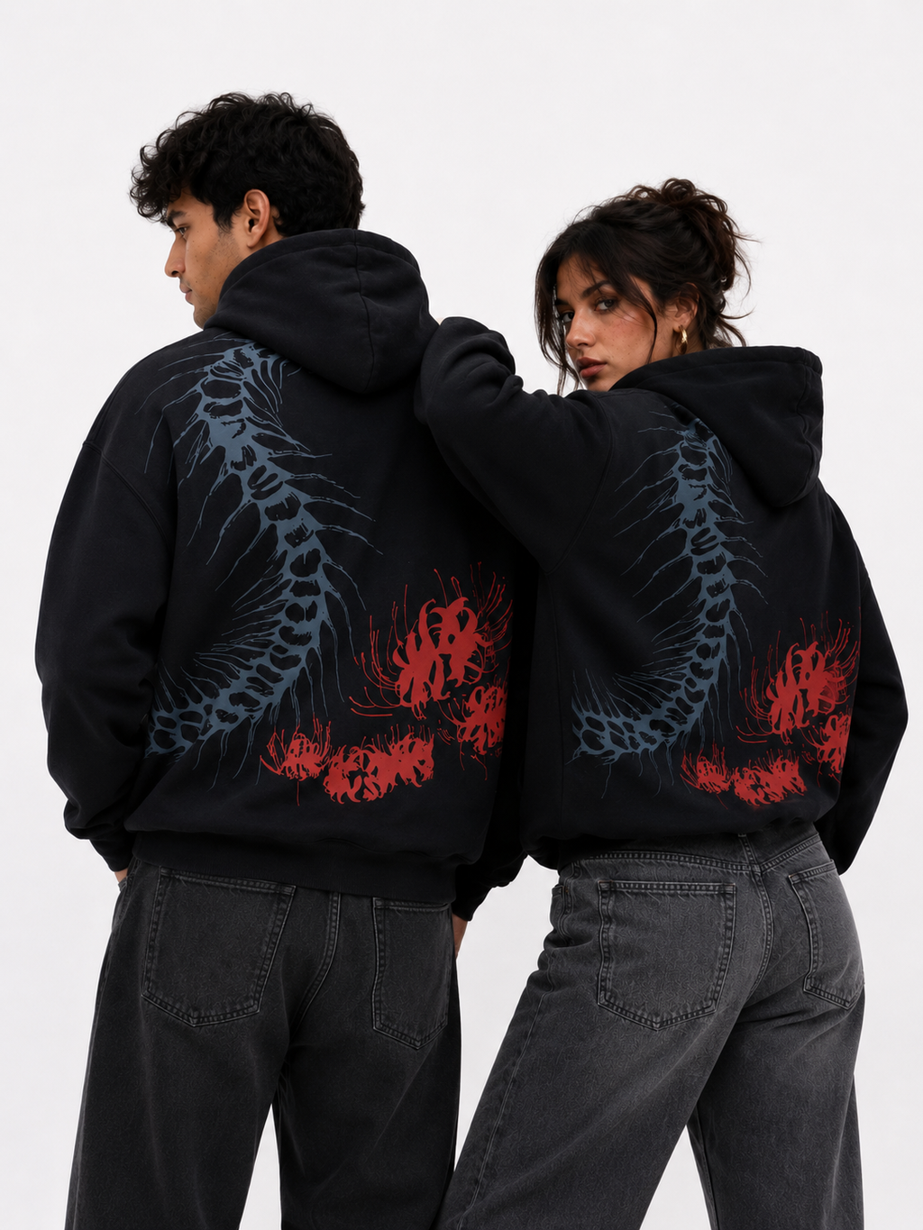 Front and back view of the Silken Spine oversized black hoodie worn by male and female models highlighting the oversized fit and bold back graphic.

