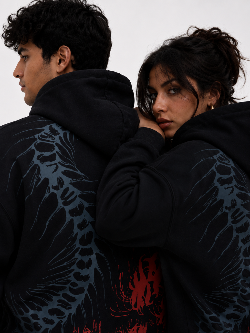 close-up of the Silken Spine oversized black hoodie showcasing the anatomical spine artwork with crimson spider lily graphics on the back.
