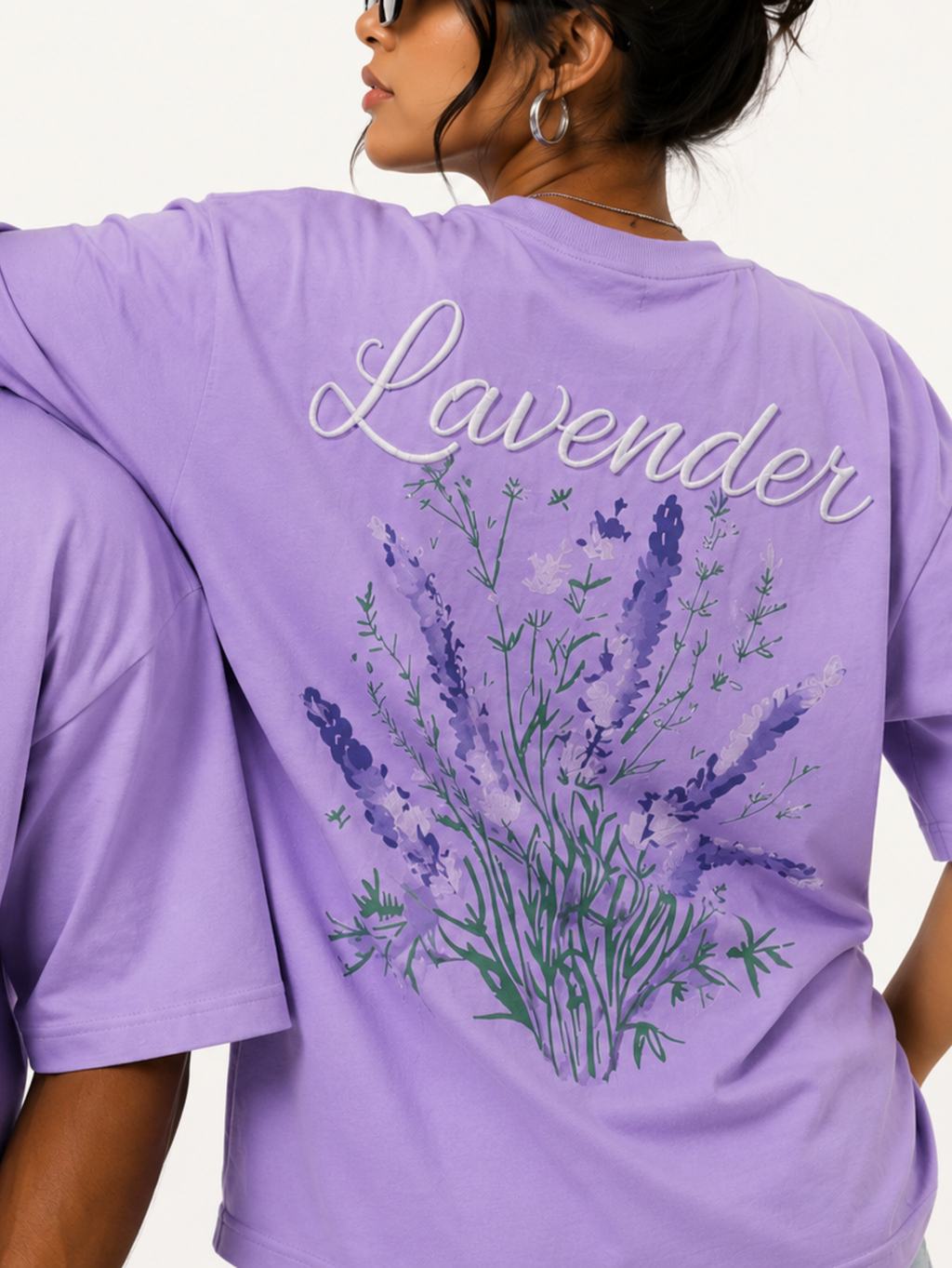 Close-up of Still Bloom lavender oversized t-shirt highlighting Calm typography, lavender floral back print, and premium cotton fabric