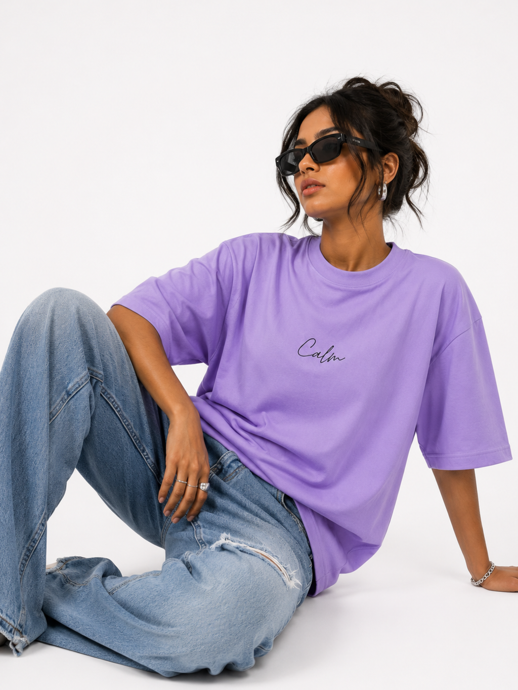 Female model wearing Still Bloom premium lavender oversized t-shirt with Calm typography and botanical aesthetic