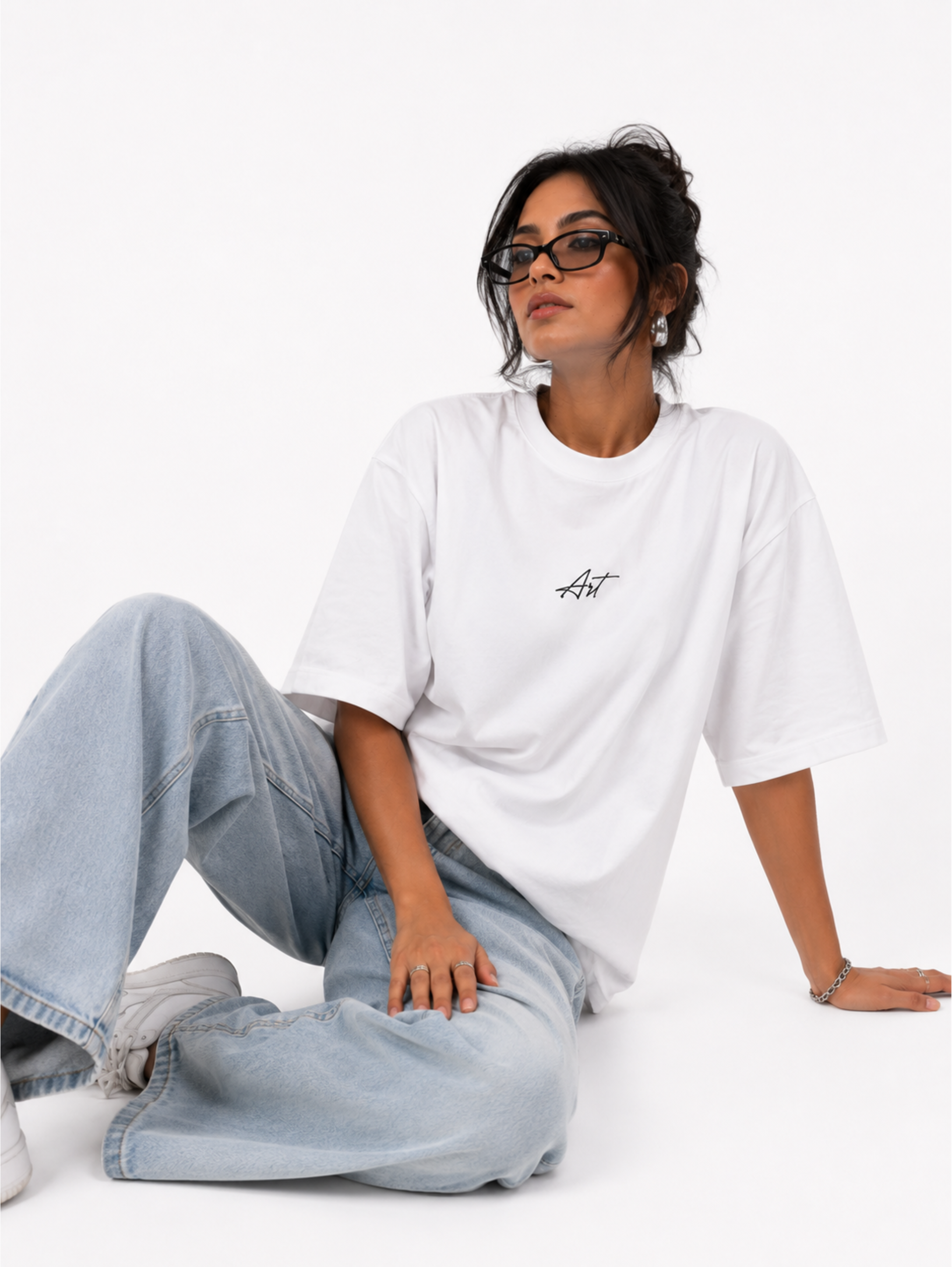 Female model wearing Undying Canvas oversized white premium oversized t-shirt with minimalist Art logo