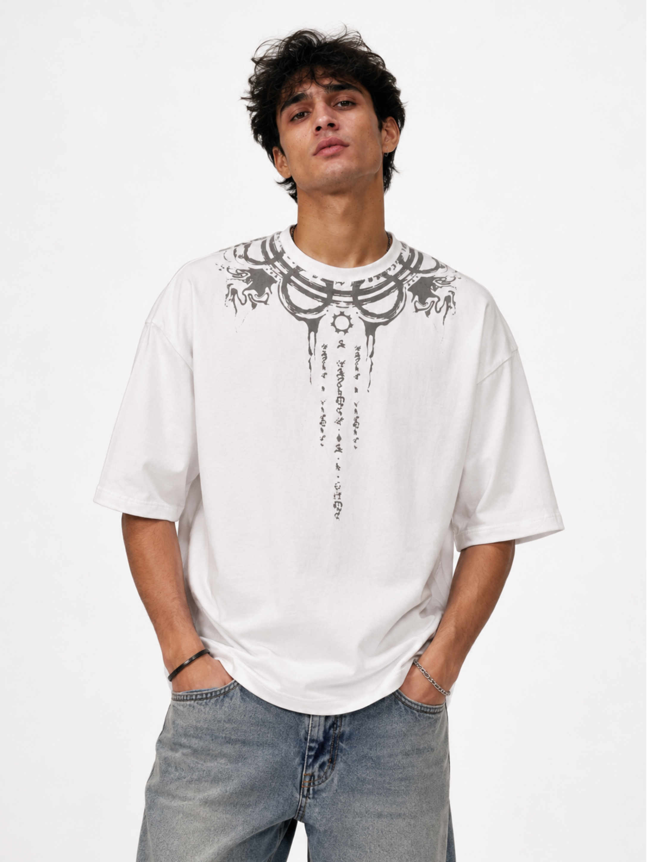 Male model wearing the Vishnu Ascendent premium oversized white cotton T-shirt by Syin&Syrah featuring celestial neckline artwork and sacred script detailing in a clean studio portrait.