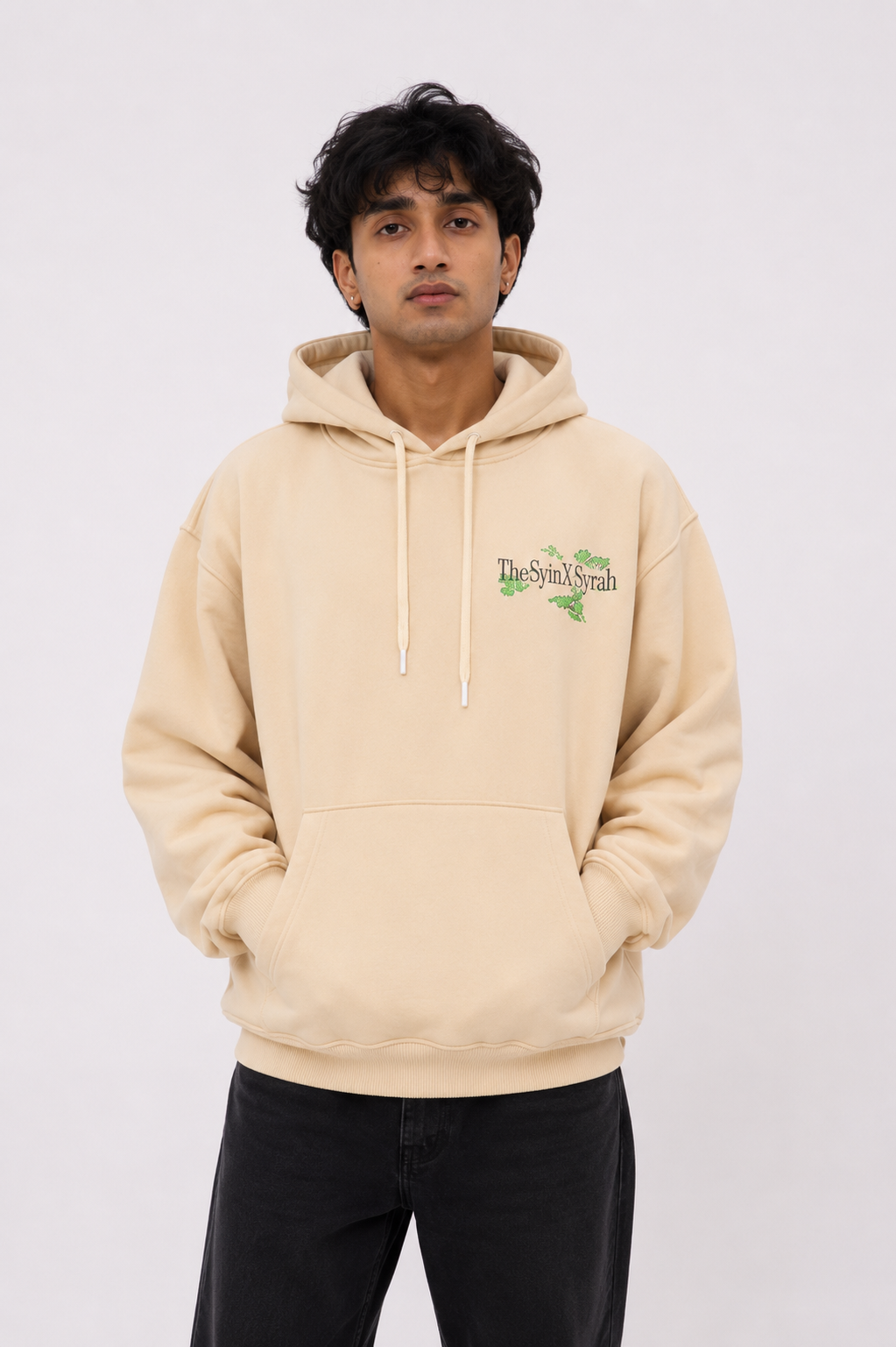 Front view of the Wild Grace oversized sand beige hoodie worn by a male model featuring the minimalist TheSyin&Syrah chest logo.