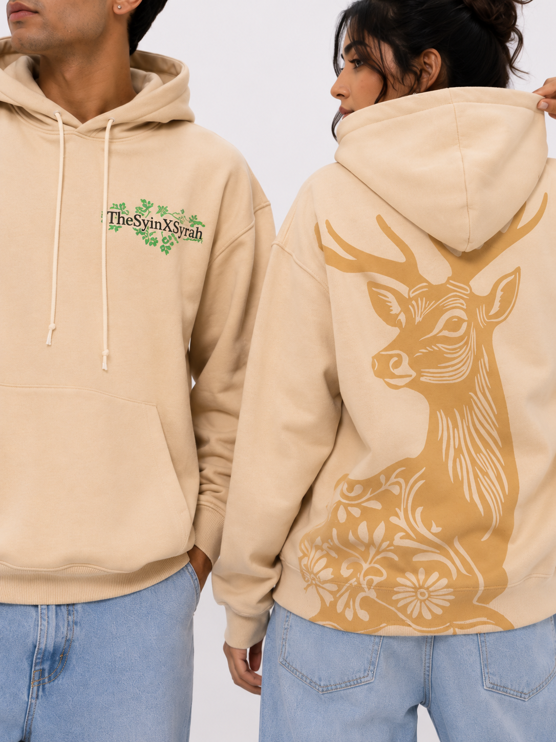Close-up of the Wild Grace oversized sand beige hoodie showcasing the embroidered-style chest logo and detailed deer artwork on the back.