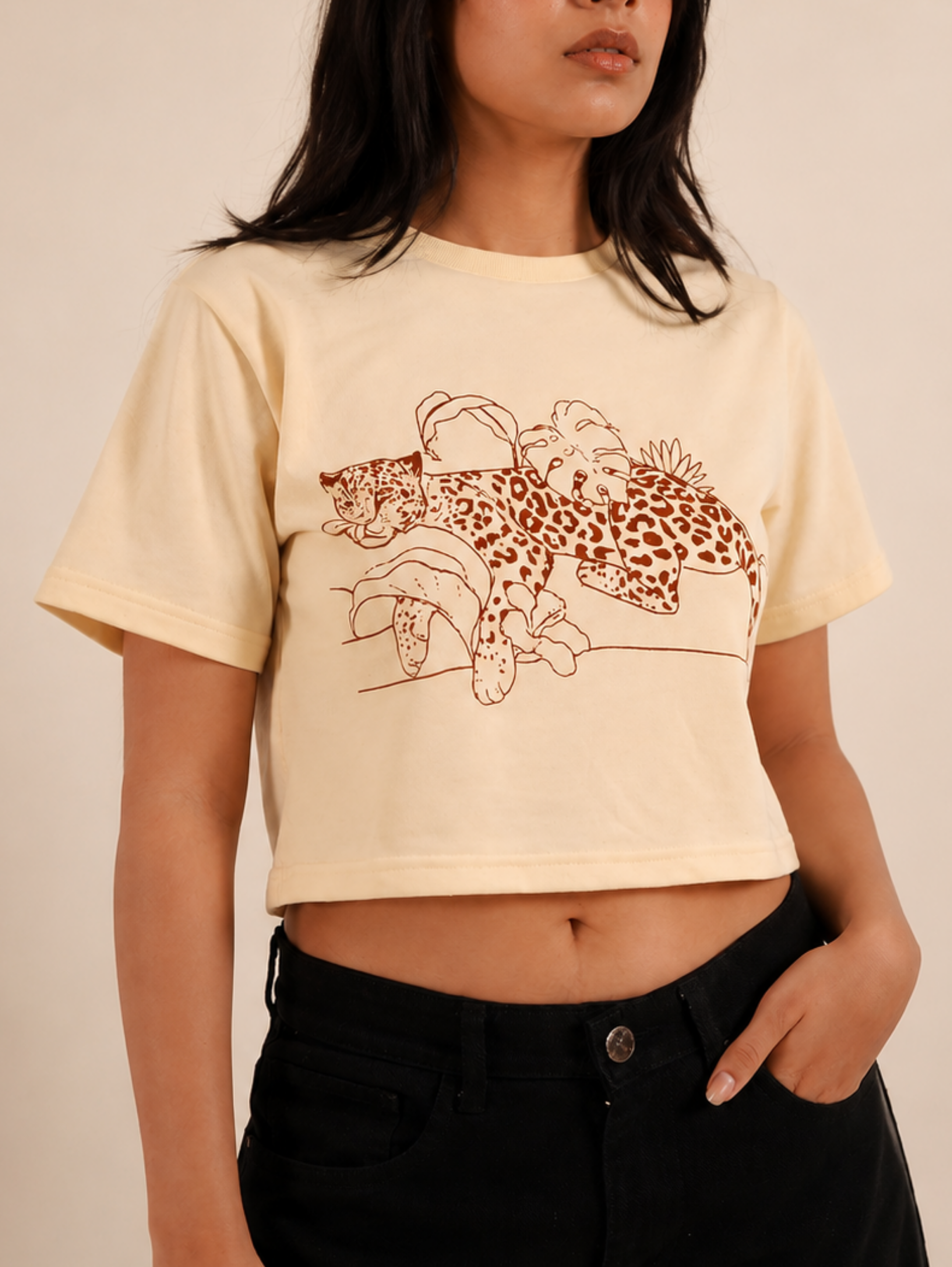 Close-up of Wild Rest leopard botanical graphic printed on cream crop top