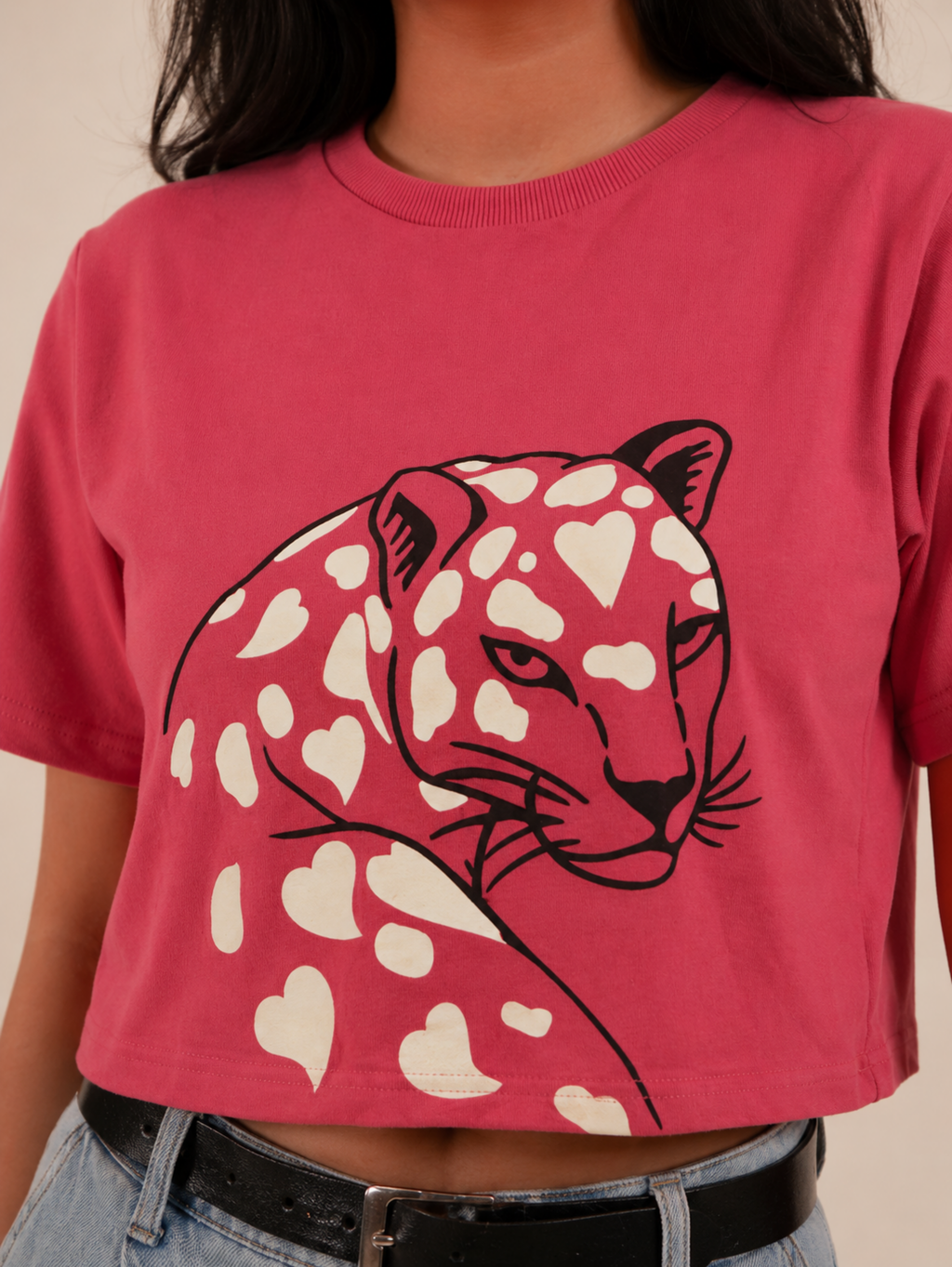 Close-up of Wild Romance leopard illustration with heart-shaped pattern on rose pink crop top
