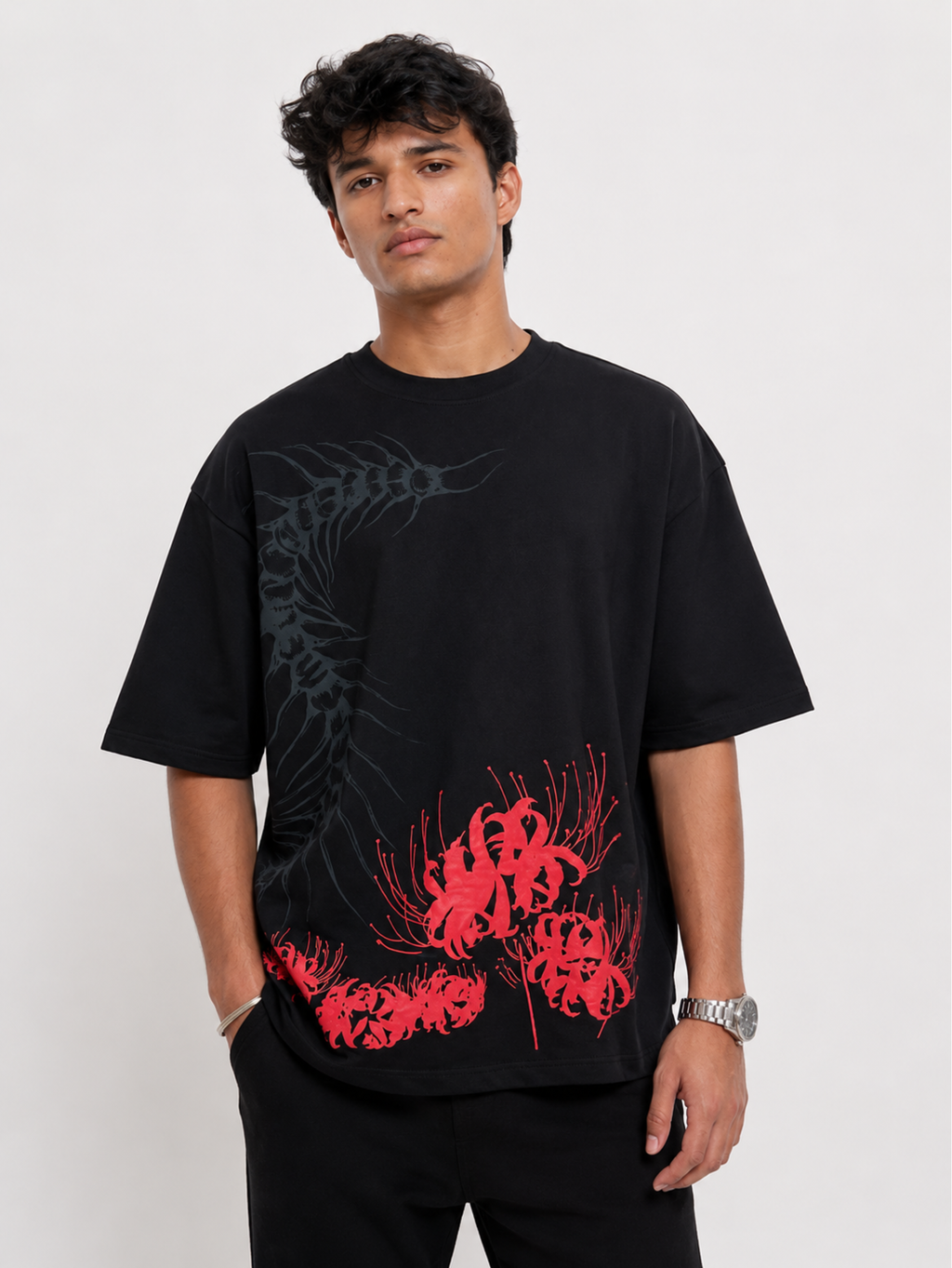 Male model wearing the Silken Spine premium oversized black cotton T-shirt by SYIN & SYRAH featuring an abstract spine graphic and bold red spider lily print.
